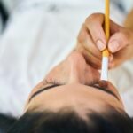 Illustrazione di un estetista che dimostra come modellare le sopracciglia con un pennello.